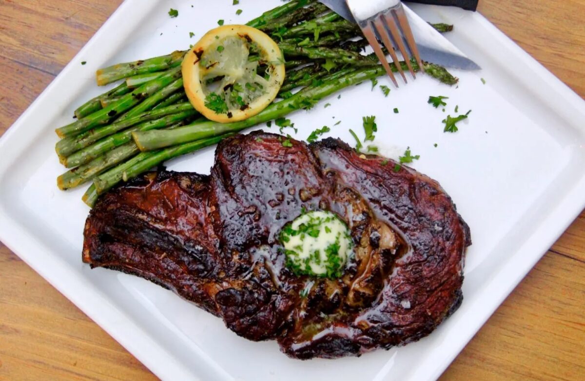 sous vide and seared ribeye stead on a plate with asparagus.