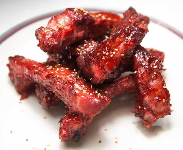Chinese roast pork (char siu) ribs on a plate topped with sesame seeds