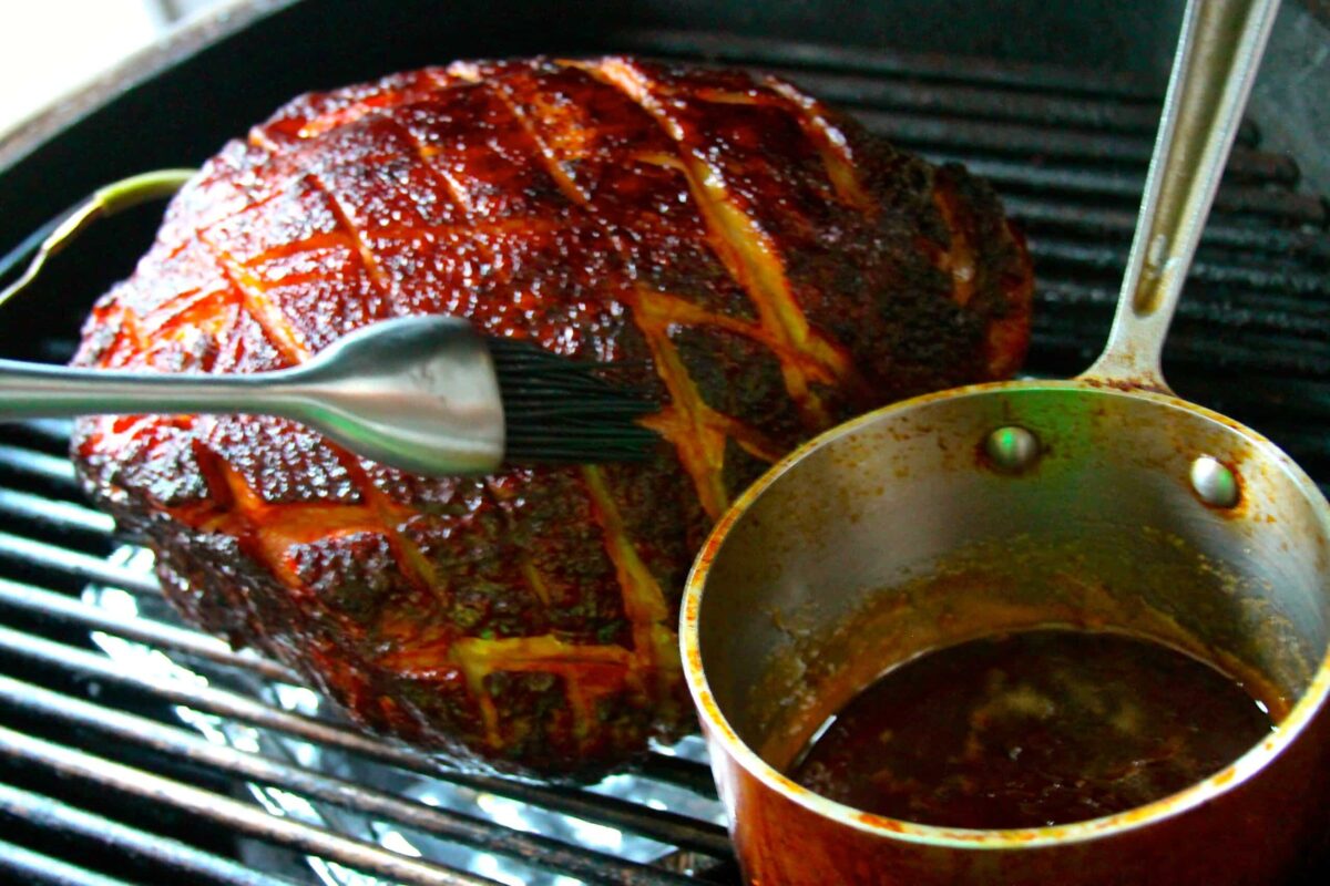 ham on a grill bring brushed with glaze.