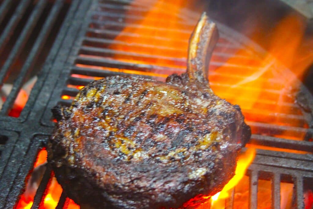 steak on a grill with flames.