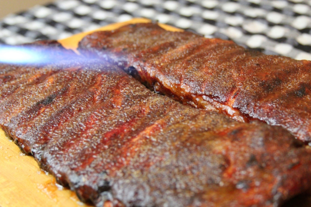 Sugar being melted on top of ribs with a torch