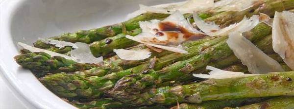 Grilled asparagus spears topped with cheese shavings