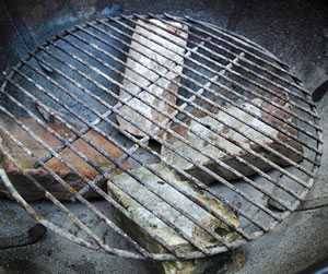 Bricks holding up the charcoal grate on a kettle grill.