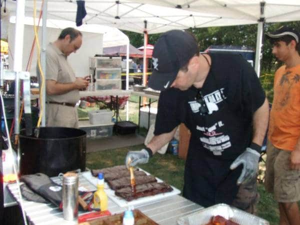 man saucing ribs in competition