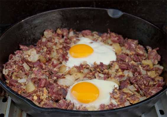 Skillet with corned beef hash topped with eggs