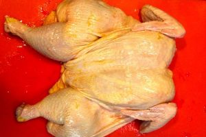 Flattened spatchcocked chicken on cutting board