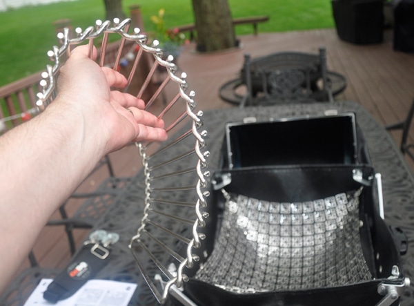 A hand holds a shiny metal object.