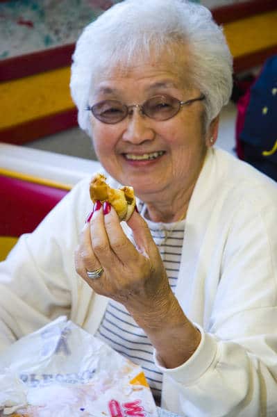old lady eating a hot dog