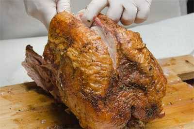 slicing breast meat from a turkey