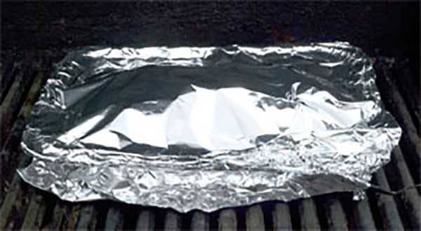lasagna wrapped in aluminium foil on a grill