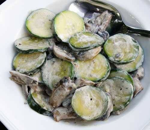 Slices of zucchini and chunks of mushrooms coated in sour cream
