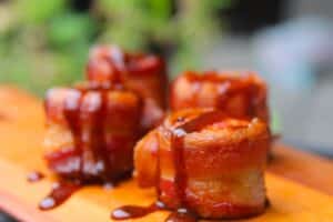 BBQ sauce drizzled bacon wrapped sausage bites.