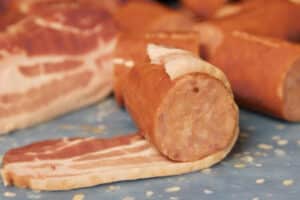 wrapping sausage in bacon.