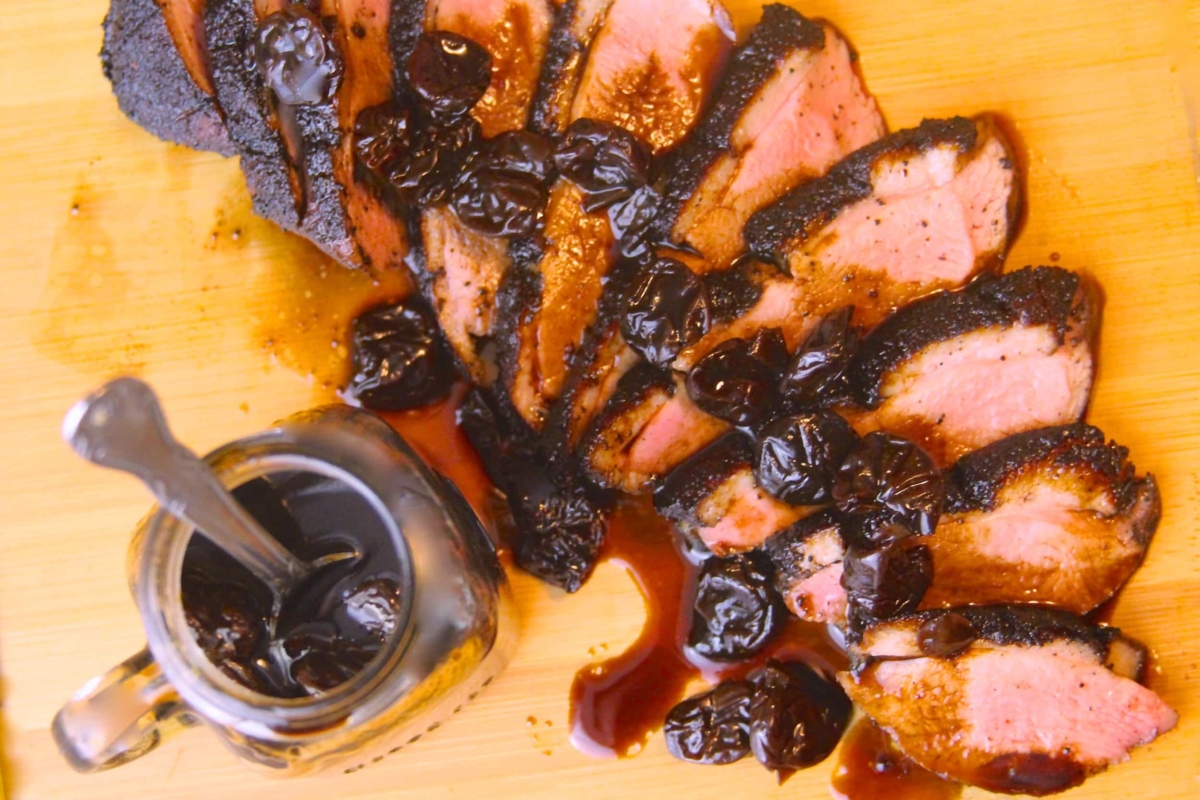 Sliced duck breast with balsamic-cherry reduction.