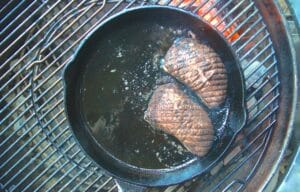 Duck breast searing in a pan.