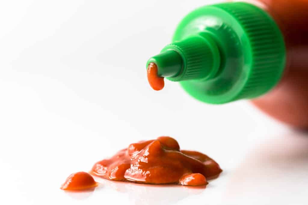 Dripping bottle of Sriracha.