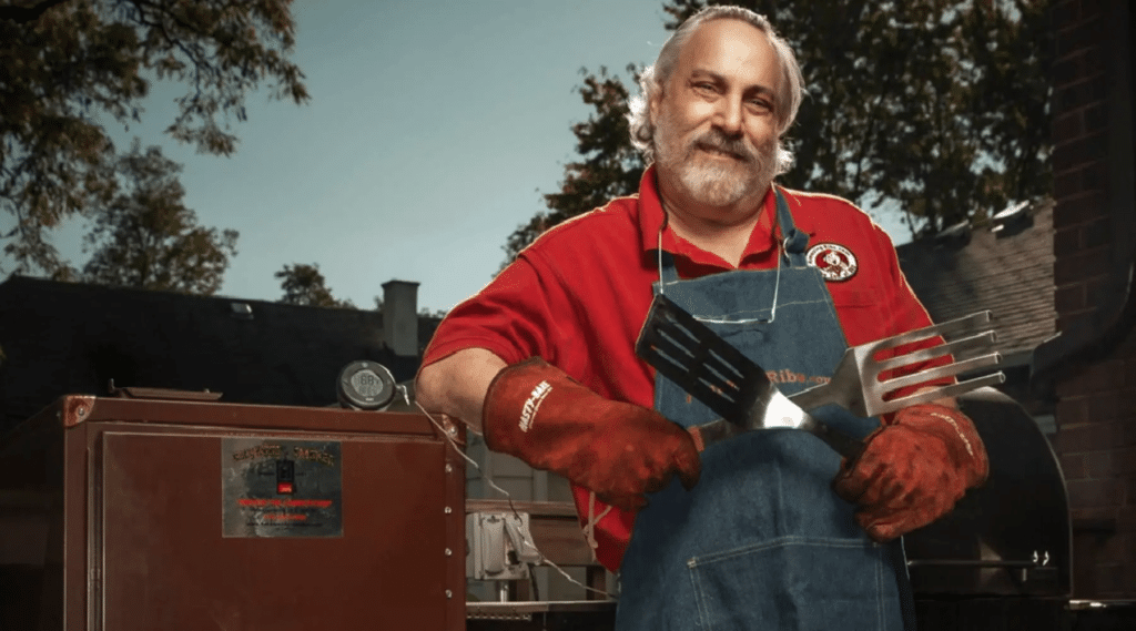 Meathead standing next to a smoker.