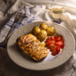 miso maple salmon a la nobu on a plate with potatoes and tomatoes.