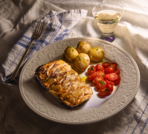miso maple salmon a la nobu on a plate with potatoes and tomatoes.