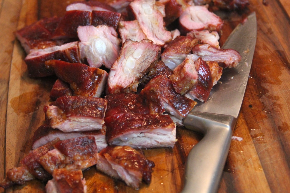 smoked pork rib tips and knife on cutting board.