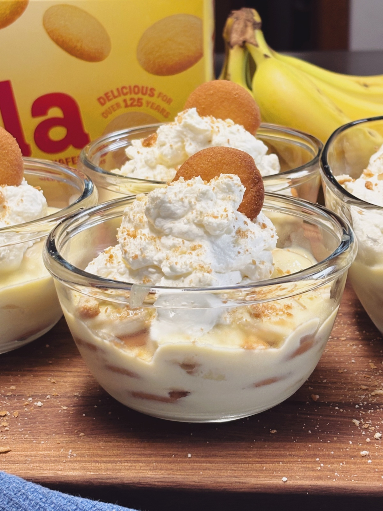 Banana pudding in glass bowls topped with whipped cream